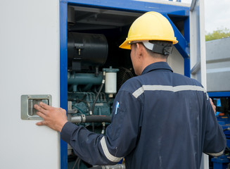 Worker engineer Man work in oil or gas refinery, turning on and off the pipeline valve torso and hand engineer yellow helmet for workers security construction worker .