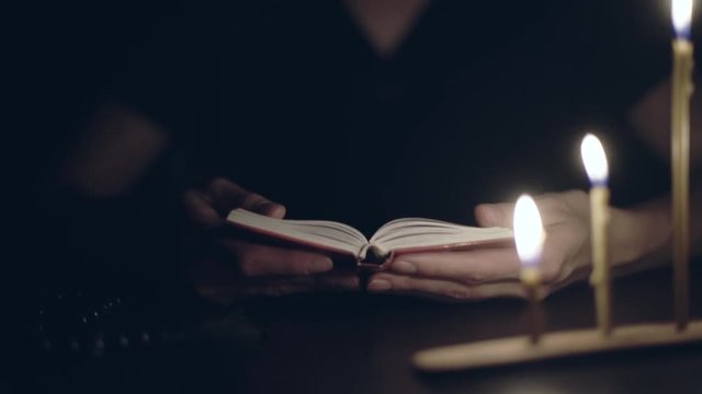 Unrecognizable human prays at night. Close up