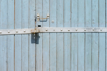 Old painted wooden garage door of grey color
