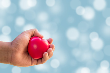 Close up of hands holding red heart. Family, love and health care concept