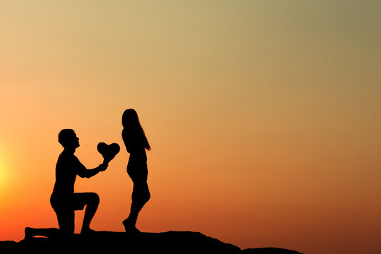 Silhouette of attractive confident half naked man propose marriage to bikini womanSilhouette of attractive confident half naked man propose marriage to bikini woman