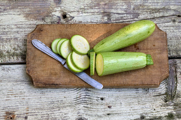 Zucchini and a knife on a wooden board