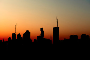 Fototapeta na wymiar silhouette of urban city sunset with tall sky scrapers, financial building
