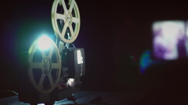 Old movie projector showing film. Footage by slider camera