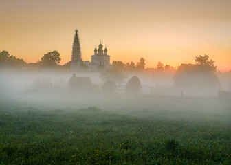 Obraz premium Misty morning overlooking the Kazan Church and the Church of St. John the Warrior in the village of Osenevo, Gavrilov-yamskiy district of the Yaroslavl region. Russia