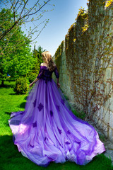 Fototapeta na wymiar blonde girl in violet dress with long plume
