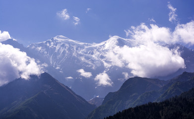 background of the high mountains covered with snow with some clouds and blue sky