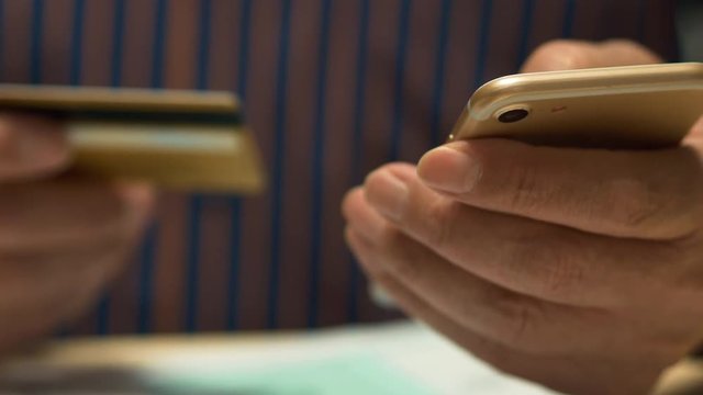 Elderly Man Text Messaging On Smartphone And Tax Form 1040, Credit Card