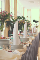 Table with dishware and tasty food, toned