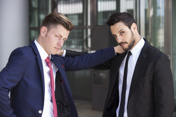 two businessmen looking serious into camera