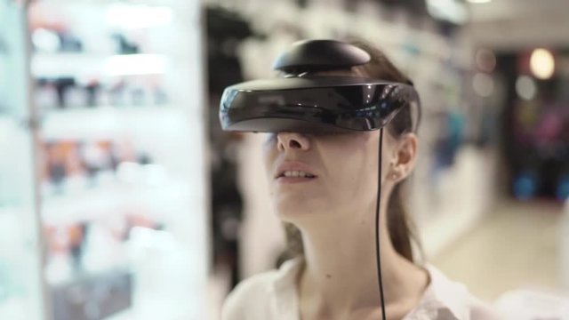Young woman getting experience in using vr-headset in a mall. Close up