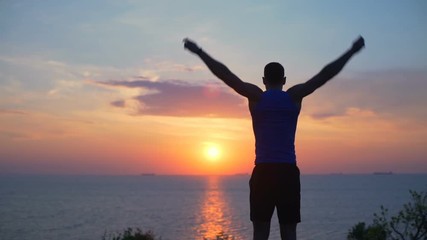 young strong man stretching rotating arms workout outdoor dawn coast slow motion