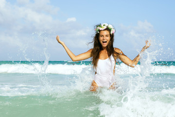 Happy woman playing and splashing in the sea