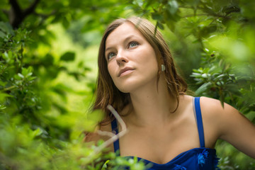 Young beautiful woman find the way home from the forest. Beautiful face and eyes, green background.