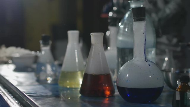 Chemical laboratory. Close-up of the flasks with the chemicals that stand on the table, boil and smoke in Slow motion