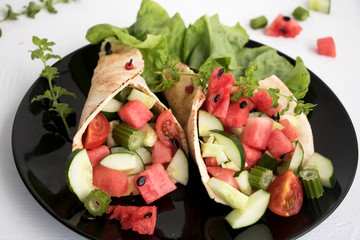 Wraps gefüllt mit Melone, Sellerie, Gurken und 
Tomaten