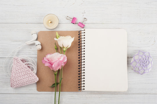 Blank notebook, pink crochet holdel, earphones