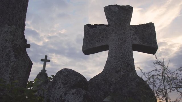 Close up dusk shot of an ancient old cross on the cemetery, 4K
