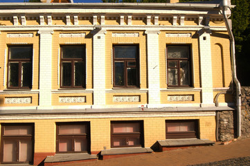 The facade of the building is yellow white, windows