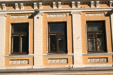 Obraz premium The facade of the building is yellow white, windows