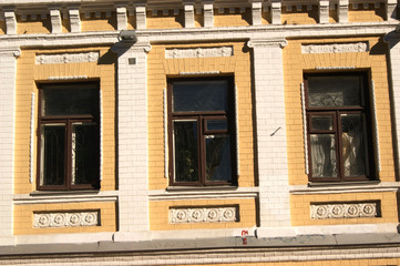 The facade of the building is yellow white, windows