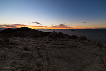 Sunset light on the Island of the Sun, Titicaca Lake, among the most scenic travel destination in Bolivia. Expansive panorama with glowing rocks in the foreground.