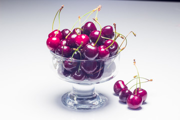 Черешня в стеклянной миске на белом фоне