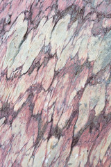 Close up of colorful rock surface, natural background, pattern and texture. Metamorphic white quartzite folded and fractured together with red coarse sandstone.