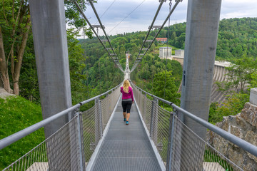 Girl walking over a suspension bridge