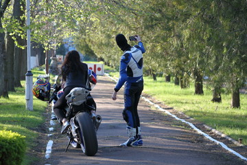 Fototapeta premium Guy with a girl on motorcycle do selfie on the phone