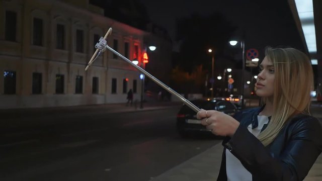 A young blonde girl makes a selfie photograph using a stick of stick. Live and create stories for social networks.