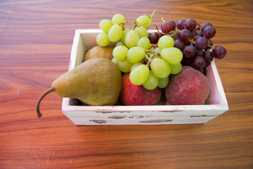 Obstkiste mit Birnen, Weintrauben und Pfirsichen