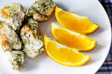 Boiled chicken breast with dill and capelin on a white plate