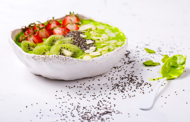 Breakfast Detox Green Smoothie  Bowl with fresh berries,kiwi and chia seeds. Food or Healthy diet concepton a white background.Super Food.selective focus.