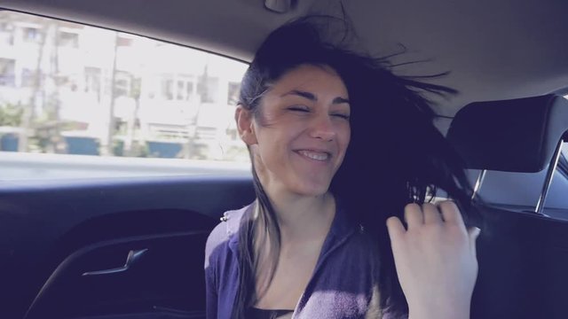 Happy Woman Singing And Dancing In Car With Wind Blowing Long Hair