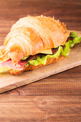 Sandwich with smoked salmon, cucumbers and cheese on the board, vertical, selective focus, closeup