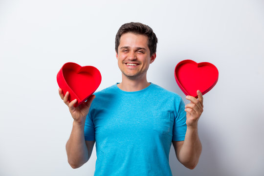 smiling man in blue t-shirt  with heart shape box