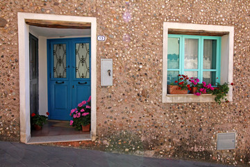 porta azzurra e finestra con fiori a Orosei (Nuoro, Sardegna)