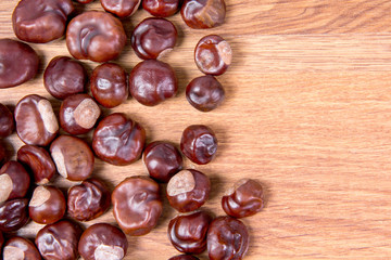 Fresh chestnuts scattered on the table, background for photo and text.