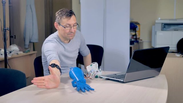 An engineer teaches a bionic hand prototype to make a fist.