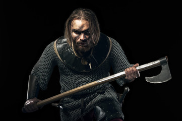 Formidable viking in armor and axe on black background