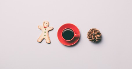 Red cup of coffee with cookie and pine cone