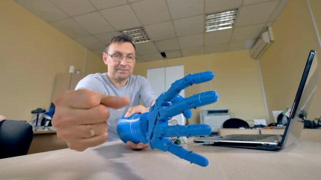 A plastic robotic arm prototype is tested in a lab.