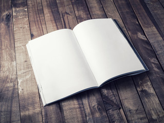 Blank open book, brochure or magazine on vintage wooden table background. Mock-up for graphic...