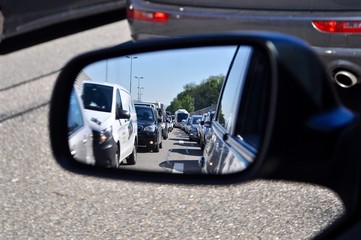 Autostau - Blick aus dem Rückspiegel auf  wartende Autos - Autokolonne / Autoschlange 