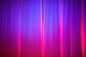 Bright pink and purple stage curtain with spotlight. Abstract background.