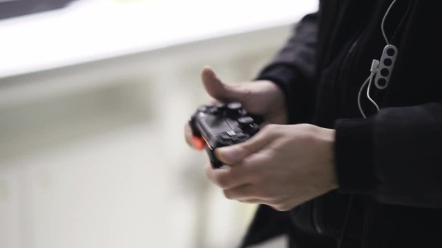 Man playing with a videogame controller in his hands. 4K