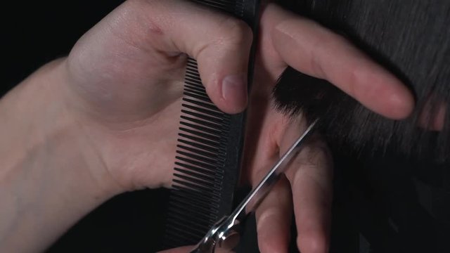 Haircut with scissors close up.