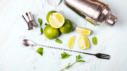 Mojito Cocktail.Mint, lime, ice ingredients for making  and bar utensils.Cold Drink on light background.Top View.Copy space for Text.selective focus.