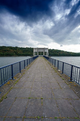 Fototapeta premium Empty pier and railings with diminishing perspective, clouds in sky, Belgium.